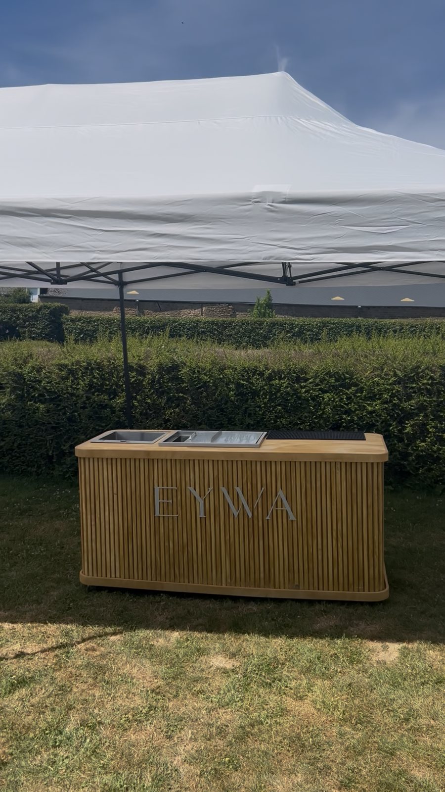 Le bar mobile EYWA installé sous un barnum blanc, prêt pour le service